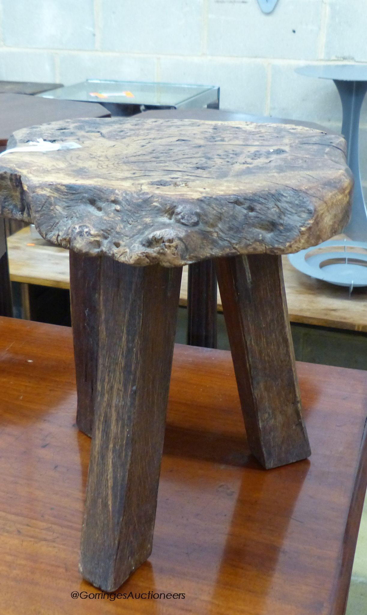 A provincial burr ash topped tripod stool, stamped Wanderwood, width 32cm, height 33cm